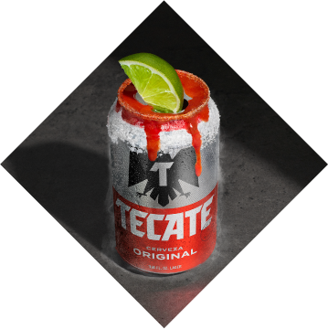 Tecate® Original can with a lime, salt and some hot sauce on top.